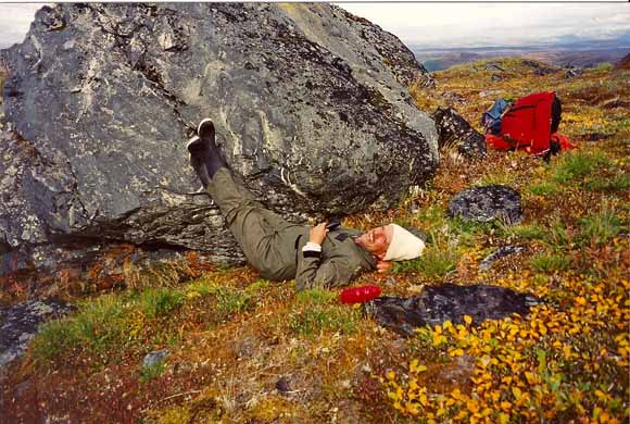 Photo of geologist with his feet up on an outcrop