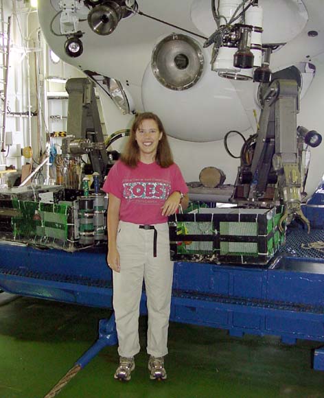 Photo, Michelle standing on deck, small sub in background