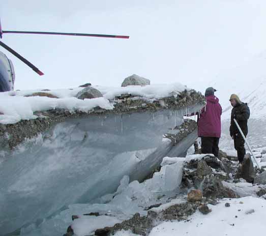 photo of geologists beside faulted ice.  Helicopter parked on upthrown side