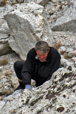 photo of Jim in the field beating on an outcrop with a hammer