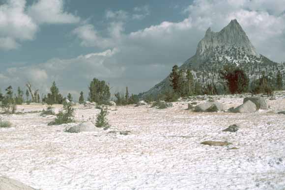 photo of sharp-pointed summit of peak; snow in the foreground