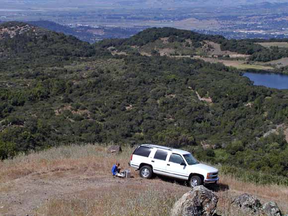 photo of Vicki putting in a gravity station up on a hill with lots of flatland vista in the background