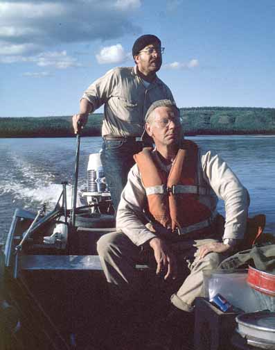 photo, closeup of two men in a small boat.  Photo taken from the bow looking toward the stern