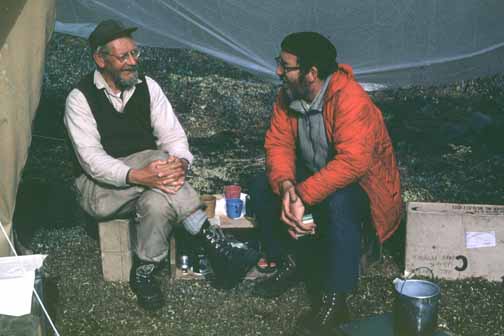 photo, two men under a tarp in camp