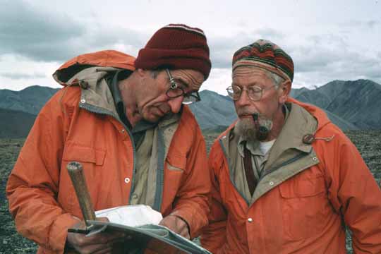 photo, closeup of Hill and Bill in orange parkas discussing map relations